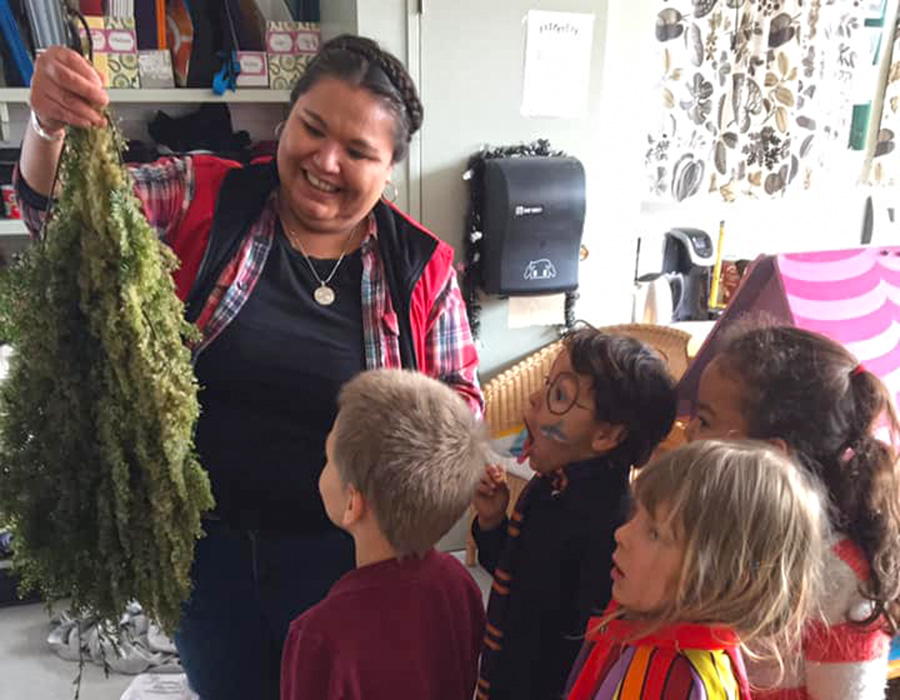 Charlene Joseph shows students a hemlock bough covered in herring roe